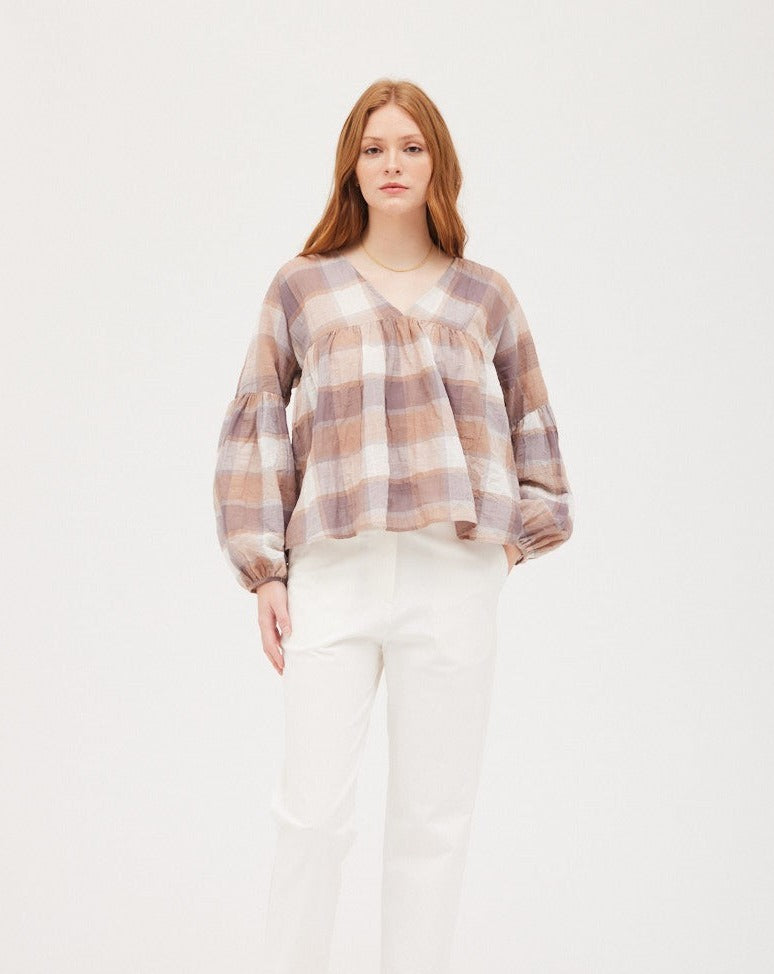 The Plaid Balloon Sleeve Blouse is the perfect piece to liven up any wardrobe. Its neutral pattern and flowy fit will ensure you look stylish, while its puff sleeve adds a modern twist.