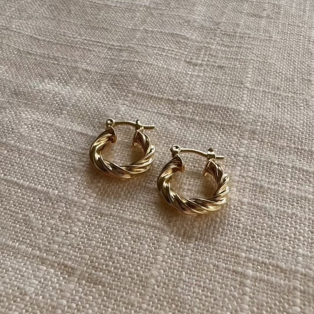 The Twisted Hoop Earring will add a touch of elegance to any look. Featuring a twisted texture and a hinge style closure, these 18k gold filled earrings are the perfect midi hoop. 